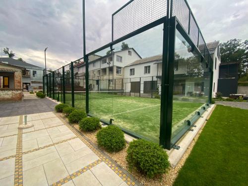 a tennis court with a net on a lawn at Iris Hotels Resort in Vorzelʼ
