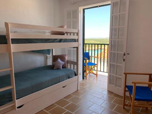 a bedroom with bunk beds and a balcony at Apartamento en frente de la playa in Son Parc