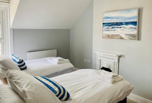 מיטה או מיטות בחדר ב-Coast House Cromer - Sleeps 15, hot tub, sea views
