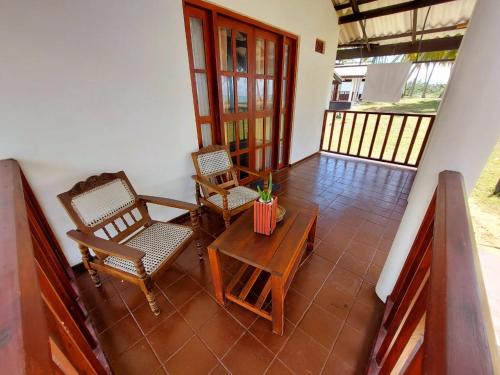 a room with two chairs and a table and a balcony at Helios Beach Resort in Tangalle