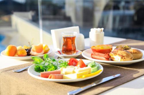 a table with three plates of food and a drink at Azka Hotel in Bodrum City