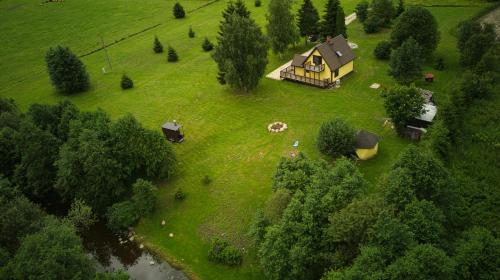 an aerial view of a house on a green field at Ilvese Cottage Lintsi jõe kaldal 