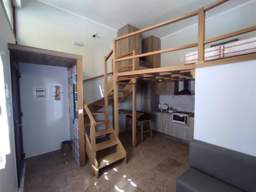 uma cama alta num pequeno quarto com uma cozinha em Lakmos Studios em Ioannina