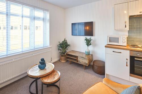 a living room with a table and a kitchen at Host & Stay - West Crescent Apartments in Darlington
