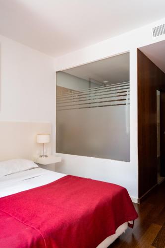 a bedroom with a bed with a red blanket at Hotel Vila D'Óbidos in Óbidos