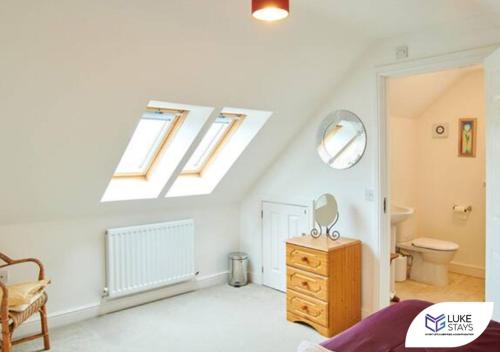 sypialnia na poddaszu z łóżkiem oraz łazienka z oknem w obiekcie Luke Stays - The Green w mieście West Cornforth