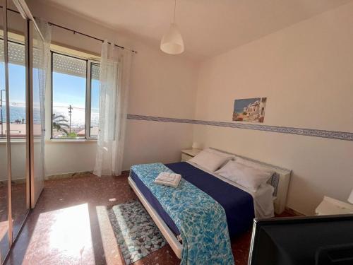 - une chambre avec un lit et une grande fenêtre dans l'établissement Scauri Holiday, à Minturno
