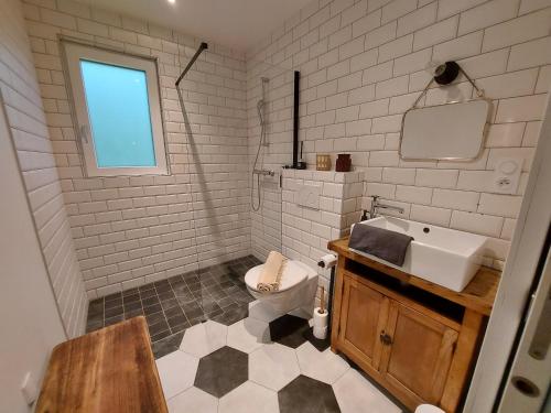 uma casa de banho branca com um lavatório e um WC em PURE, maison au calme à 10 min du centre ville em Quimper