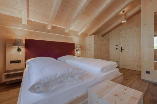 a bedroom with a large white bed and a wooden ceiling at Panorama in Sesto