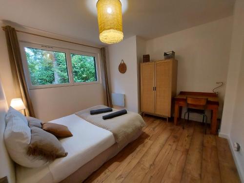 1 dormitorio con cama, ventana y escritorio en PURE, maison au calme à 10 min du centre ville en Quimper