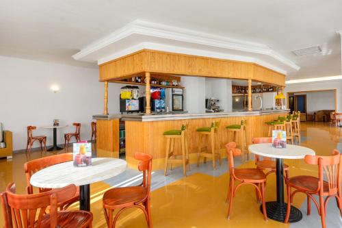 サン・アントニオ・ベイにあるHotel Apartamentos Vibra Monterreyのテーブルと椅子のあるレストラン、バー