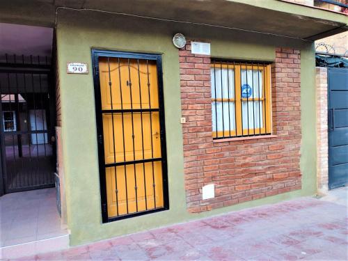 dos puertas naranjas en el lateral de un edificio en Departamento en Mendoza para Linda Estadía en Mendoza