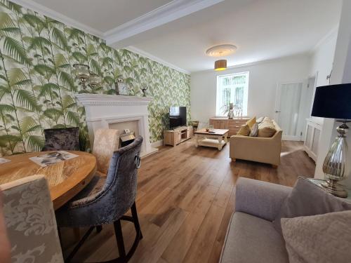 a living room with a table and a couch at Beautiful 4 bedroom house near town centre. With Bike Store Perfect for Bike Park Wales in Merthyr Tydfil