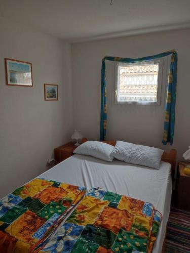 une chambre avec deux lits jumeaux et une fenêtre dans l'établissement Mas de la garrigue 13, à Saint Pierre La Mer