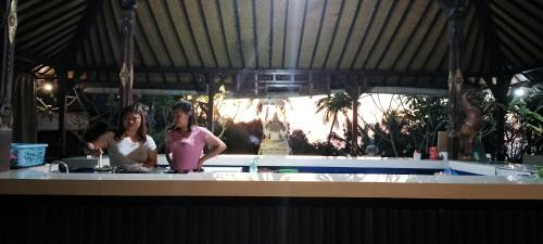 two women standing in a kitchen preparing food at D'kailash Retreat in Singaraja