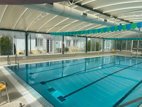 a large swimming pool with blue water at Santa Barbara Healthcare & Villas in Mariquiteira