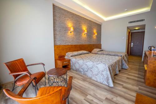 a bedroom with a bed and a table and chairs at Azka Hotel in Bodrum City
