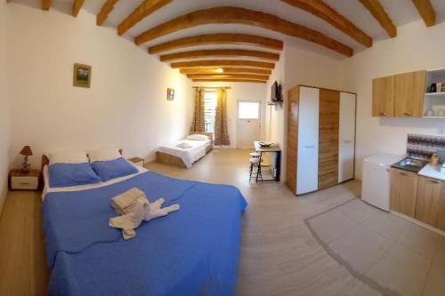 ein großes Schlafzimmer mit einem blauen Bett und einer Küche in der Unterkunft La Toscana Costinești in Schitul