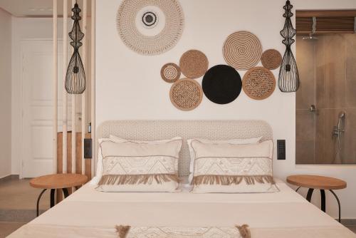 a bedroom with a large white bed with two tables at Armony Suites Milos in Paliochori