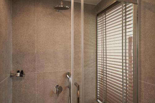 a bathroom with a shower with a glass door at Armony Suites Milos in Paliochori