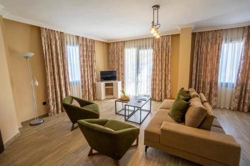 a living room with a couch and chairs and a television at Azka Hotel in Bodrum City