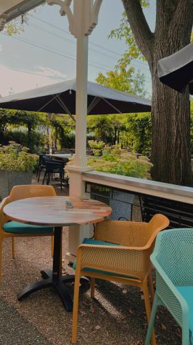 a table and chairs sitting next to a tree at Hotel Bentheimer Hof in Bad Bentheim