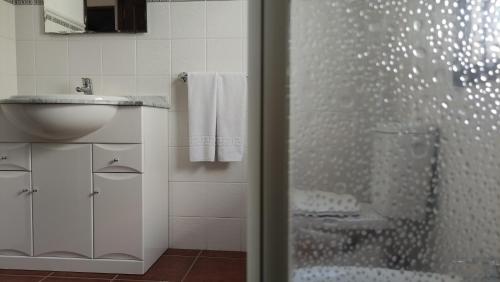 a white bathroom with a shower and a sink at Casa Marina in Tías
