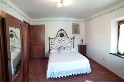 a bedroom with a white bed and a mirror at Ai tre Campi in Fornaci di Barga