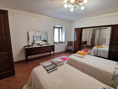 a large room with two beds and a mirror at Ai tre Campi in Fornaci di Barga