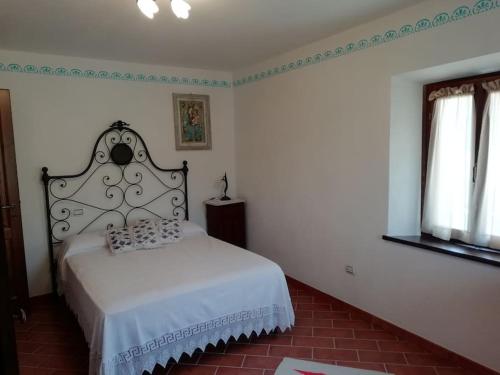 a bedroom with a white bed and a window at Ai tre Campi in Fornaci di Barga