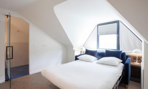 a bedroom with a white bed and a window at Hotel The Shepherd in Leuven
