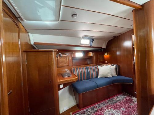 a small cabin with a blue seat in a boat at Beautiful and comfortable sailboat with secure parking available in Barcelona