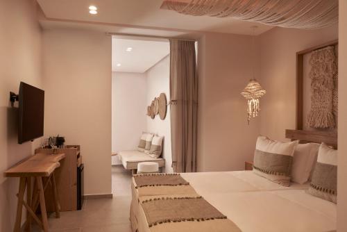a hotel room with a bed and a chair at Armony Suites Milos in Paliochori