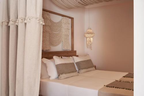 a bedroom with a bed with white sheets and pillows at Armony Suites Milos in Paliochori