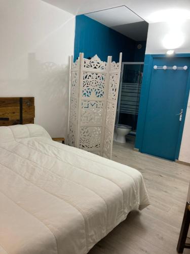 um quarto com uma cama e uma porta azul em La Chambre du Patio em Le Luc