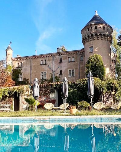 un château avec une piscine en face d'un bâtiment dans l'établissement Hôtel Château Du Rey, à Saint-André-de-Majencoules