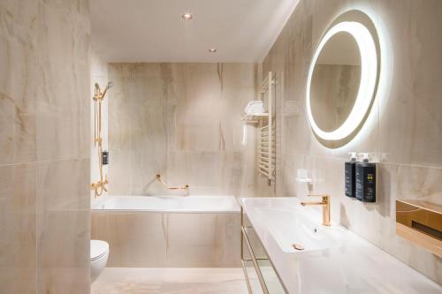 La salle de bains est pourvue d'un lavabo, de toilettes et d'un miroir. dans l'établissement Mamaison Hotel Riverside Prague, à Prague