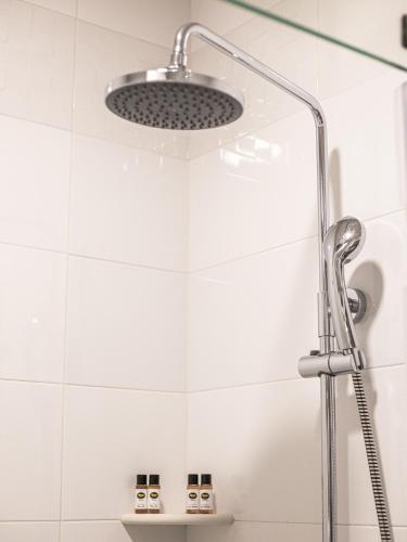 a shower with a shower head in a bathroom at Boutique Hotel 32 in Batumi