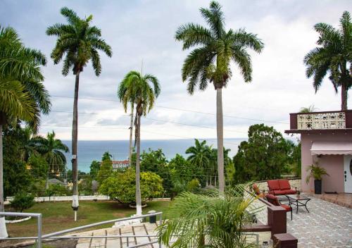 a view of the ocean from a house with palm trees at Bella Vista Vacation in Montego Bay