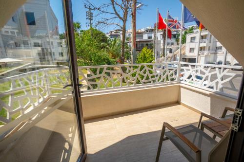 einen Balkon mit 2 Stühlen und Stadtblick in der Unterkunft Azka Hotel in Bodrum City