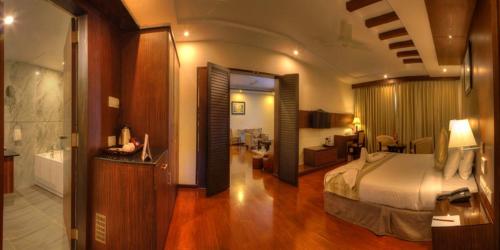 Habitación de hotel con cama y baño en Hotel Le Ruchi The Prince, en Mysore