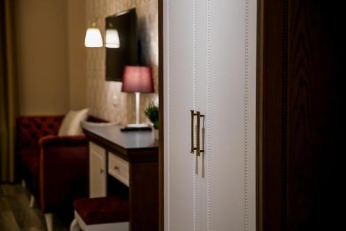 a door to a hotel room with a desk and a room at Legacy Boutique Hotel in Korçë