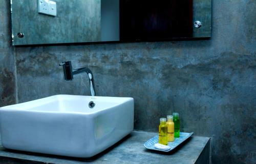 a bathroom with a sink and bottles on a counter at Chill House make a Good Story with infinite Ocean Surf and Stay in Weligama