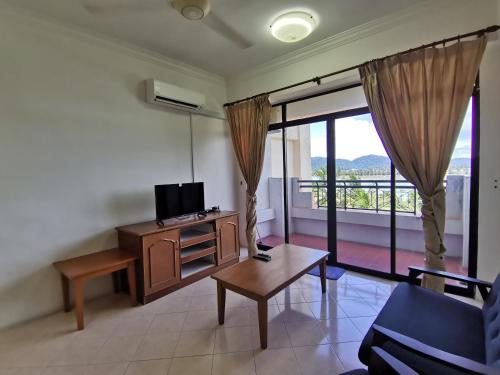 a living room with a tv and a couch and a table at My Getaway Home @Marina Cove in Lumut