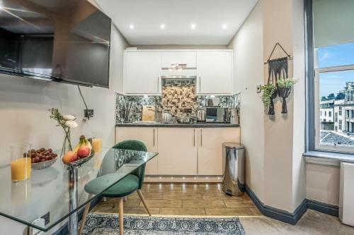a kitchen with a counter and a table with chairs at Stylish Central Edinburgh Abode in Edinburgh