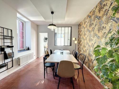 comedor con mesa y sillas en Appart LA MANUFACTURE - Maison 1911 - confort & prestige en Gien