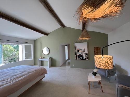 1 dormitorio con cama, lámpara y silla en Mas Arietis, en Saint-Rémy-de-Provence