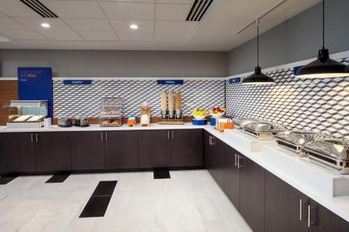 a large kitchen with brown cabinets and white counter tops at Holiday Inn Express Washington DC Downtown by IHG in Washington