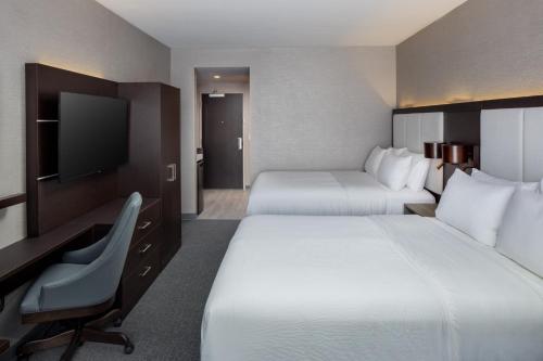 a hotel room with two beds and a desk and a television at Holiday Inn Express Washington DC Downtown by IHG in Washington
