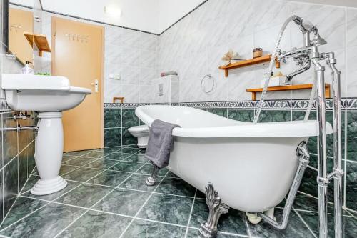 a bathroom with a tub and a sink and a toilet at Utulny a prostorny podkrovni byt s krbovymi kamny in České Budějovice